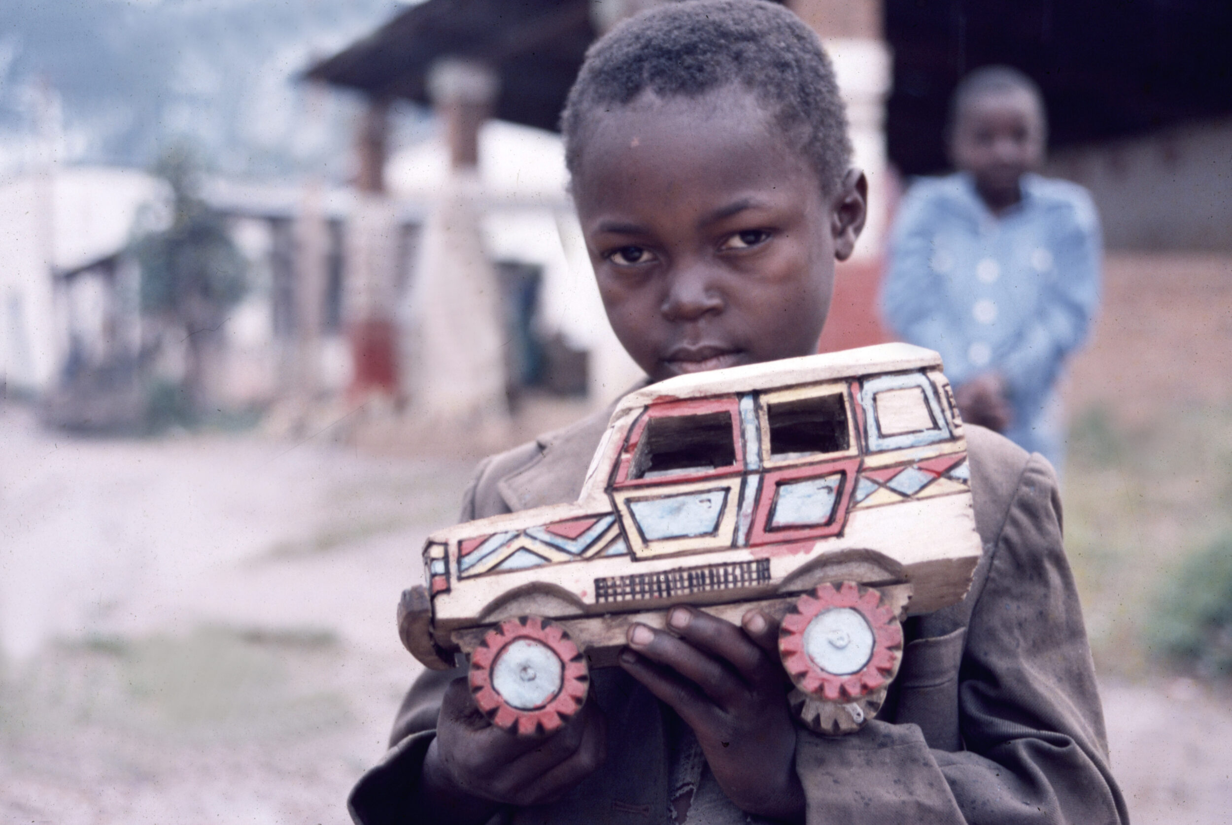 Tansanisches Kind hält selbst gebastelten Geländewagen