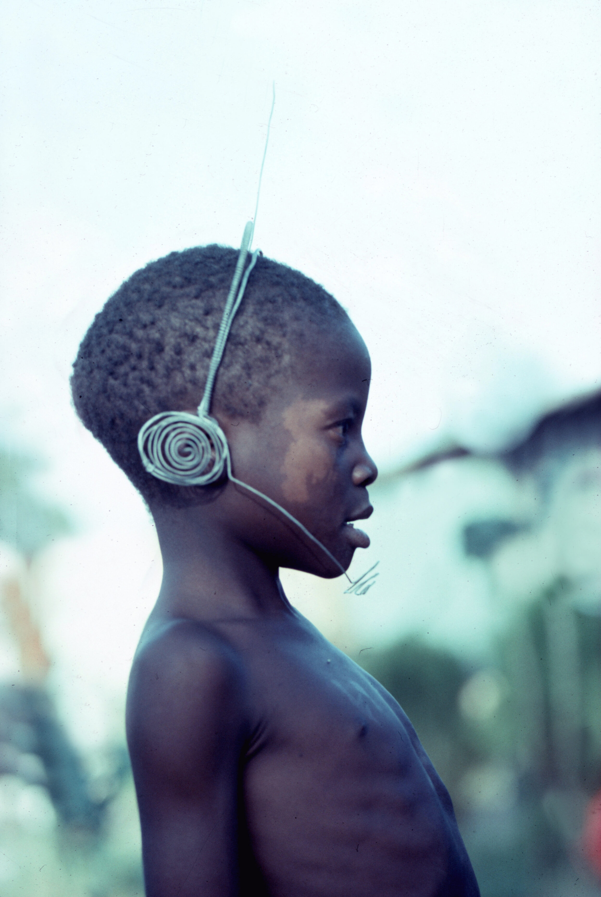 Kind aus Simbabwe trägt selbst gebastelte Kopfhörer mit Sprechfunkgerät