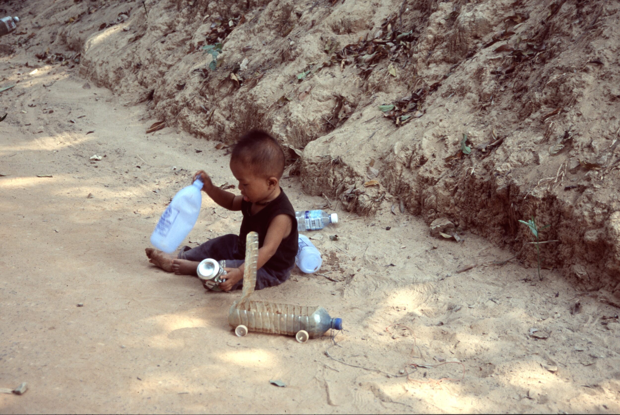 Kleinkind aus Kambodscha beim Spielen mit Auto aus Plastikflasche