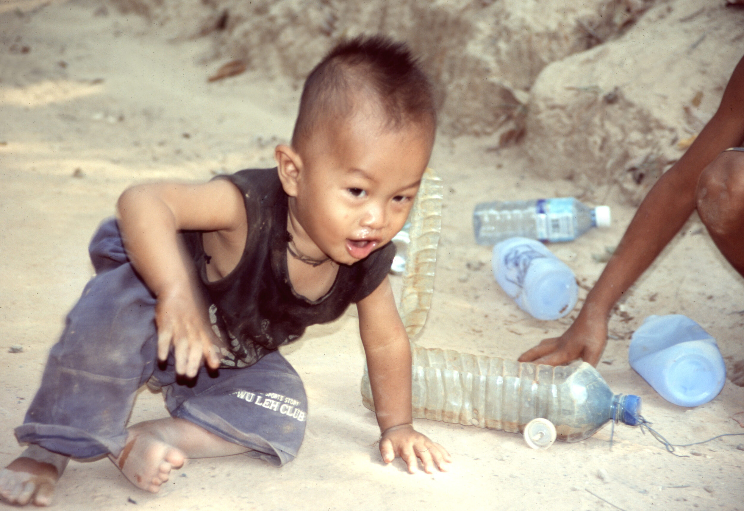 Kleinkind aus Kambodscha beim Spielen mit Auto aus Plastikflasche