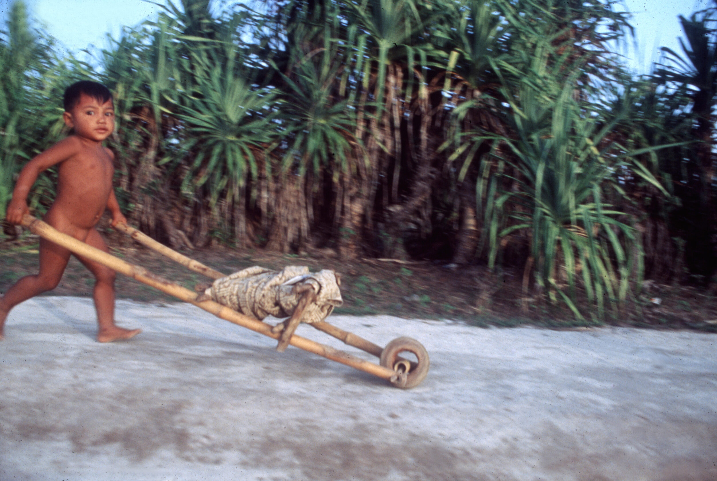 Kind mit Schubkarre aus Bambus, Insel Lombok, Indonesien